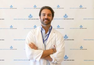 En la imagen, el doctor Leonardo Rodríguez, otorrino del Hospital San Juan de Dios de Córdoba, posa delante de un roll up con los logotipos del centro