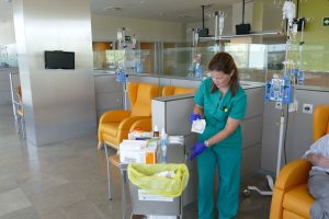 Enfermera prepara a paciente para tratamiento de quimioterapia